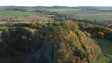 Sonbahar boyunca Polonya 'da uçurumları, ormanları ve tarlaları olan sönmüş volkanların havadan görünüşü. Volkanik manzara, jeoloji, doğa yolculuğu ve kırsal manzara kavramı.