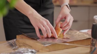 Ellerin ahşap mutfak tezgahında çiğ tavuk göğsünü yağ ve baharatla terbiye edişinin üst görüntüsü. Ev yemeği, yemek hazırlama ve sağlıklı ev yemeği kavramı..