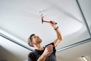 İçerideki çekiçle çivi çakan bir adam. Kurulum işi, onarım süreci ve profesyonel inşaat hizmeti kavramı.