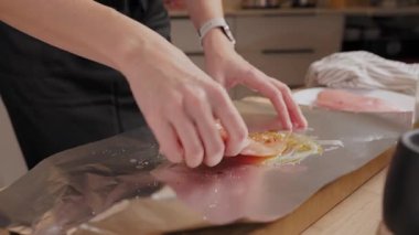 Ellerin ahşap mutfak tezgahında çiğ tavuk göğsünü yağ ve baharatla terbiye edişinin üst görüntüsü. Ev yemeği, yemek hazırlama ve sağlıklı ev yemeği kavramı..