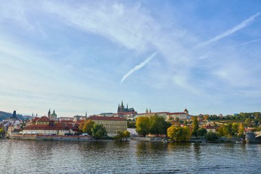 Prag Kalesi 'nin panoramik manzarası ve Vltava nehri boyunca sonbahar ağaçları olan şehir manzarası. Avrupa seyahati, mimari ve kültürel miras kavramı. Prag, Çek Cumhuriyeti - 20 Ekim 2025
