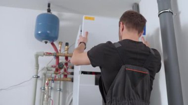 Isı pompası ünitesini denetlemek için dahili kabloları olan teknisyen açık kontrol paneli. Isıtma ve soğutma sisteminde uzman. HVAC bakımı, ev ısıtma sistemi ve enerji verimliliği kavramı