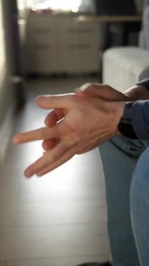 Evdeki kanepede oturan endişeli adamın sıkıca sarılmış elleri. Gergin insan sorun için endişeleniyor. Kaygı, depresyon, stres ve akıl sağlığı kavramı