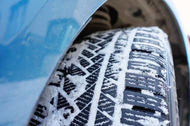 Kış arabasının lastik izleri kar ve buzla kaplı. Güvenli kış sürüş kavramı, araç çekme, kavrama ve soğuk hava yolu koşulları