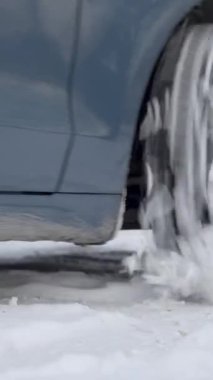 Kış yolu karla kaplıyken arabanın lastiğini kapat. Kış sürüşü, yol güvenliği ve yol tutuşu kavramı