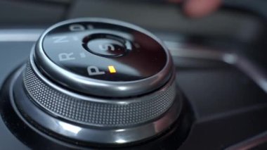 Modern araba iç mekanında el vites kolu yakın plan. Sürücü otomatik vites kutusunda sürücü kipinde iletimi değiştirir