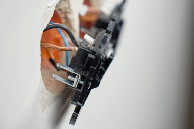 Elektrik şalteri, beyaz duvarın içinde açık kablolar ve montaj kutuları var. Elektrik prizleri yerleştirme işlemi. Elektrik tesisatı, onarım, bakım ve yenileme kavramı