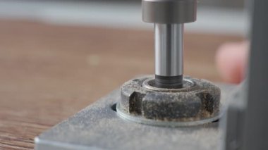 Forstner 'ın matkap ve metal bir jig kullanarak tahta bir tahtaya delik açması.