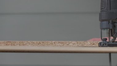 Testereyi kapat, atölyedeki tezgah üzerinde yonga kağıdı kes. Ahşap işçiliği, marangozluk ve DIY inşaat işi kavramı.