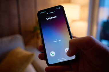 Yakın çekim, akıllı telefon oturma odasında bilinmeyen bir arama olduğunu gösteriyor. Spam çağrısı, tele pazarlama, dolandırıcılık riski ve mobil iletişim kavramı