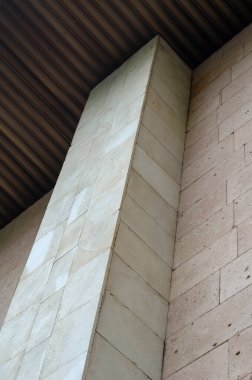 Soyut mimari kompozisyon. Yüksek bina cephesi dikdörtgen taş levhalarla çevrili. Çağdaş Mimari