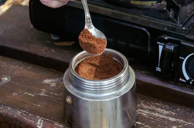 Kahve makinesi, kahve makinesi, kaşık ve park bankında taşınabilir gaz sobası. Piknik sırasında doğal kahve yapma süreci. Yaşam biçimi.