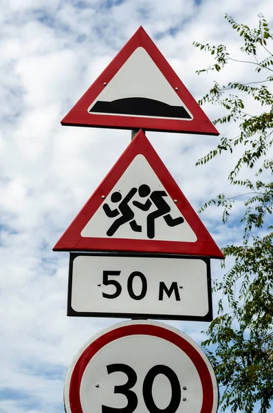 Group of red and white road signs against dramatic sky. Warning and barring road signs vertically one under one. Road safety concept. Without anybody. — Stock Image Group Red White Road Signs Dramatic Sky Warning Barring Road Stock Picture