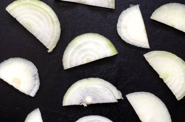 Siyah desenli arka planda yarım halkalı çiğ ampul. Beyaz ampul parçaları rastgele sıralanmış. Yukarıdan görüntüle.