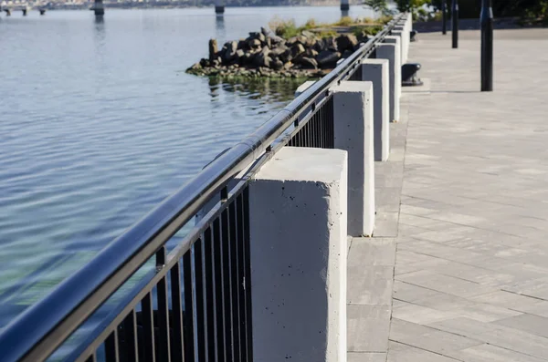 Beton kaideli ve metal çitli setin bir parçası. Tatlı su nehri boyunca siyah çitler. Kasaba halkı için dinlenme yeri.