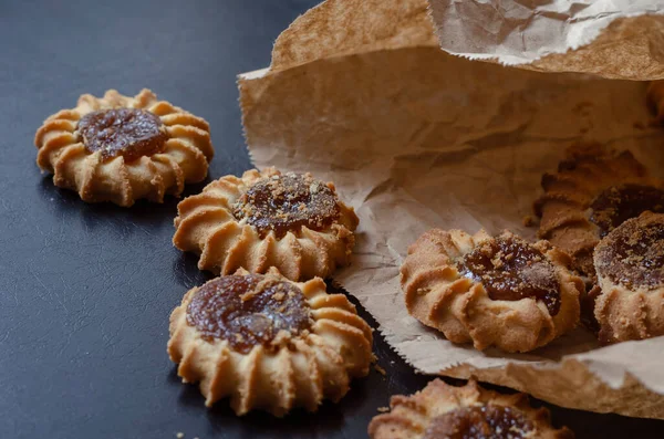 Kakor Och Papperspåse Svart Bord Läckra Söta Godsaker Med Fruktsylt — Stockfoto