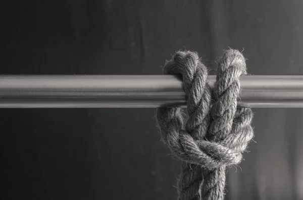 タイロープでガードレール 天然ロープ付きの金属パイプのクローズアップ 海をテーマに モノクローム — ストック写真