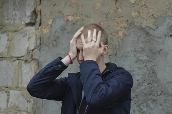 若い男は灰色のコンクリートの壁に悲しみを耐える ボールドマンは彼の顔をカバー彼の手で泣く 心理学感情概念 — ストック写真