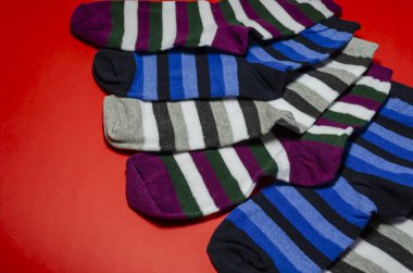 Kırmızı arka planda çizgili çoraplar. Parlak renkli yeni çoraplar. Giysiler, aksesuarlar