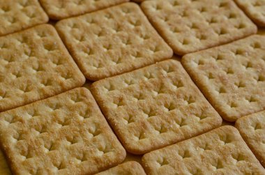 Kare tuzlu krakerler, arka plan. Yakın plan çıtır kraker..