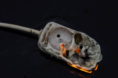 Ateş ve Elektrik Güvenliği kavramı. Elektrik tesisatı yangını. Elektrik prizleri için güç şeridi yakılıyor
