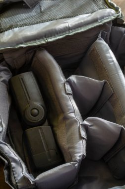 Erkek el kamera flaşını özel kamera çantasının içine yerleştirir. Fotoğraf ekipmanları için gri özel sırt çantası. Seçici odak.