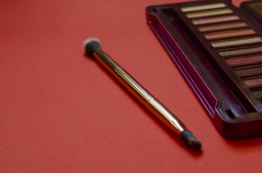 Makyaj, güzellik ve moda. Kadın kozmetik seti, göz farı ve göz kapağı. Kırmızı arka planda yeni bir kozmetik seti. Seçici odak.