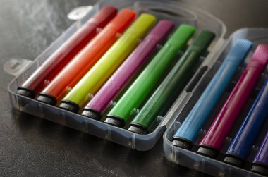 Siyah masadaki plastik kapta renkli keçeli kalemler. Yaratıcılık çizimi konsepti. Seçici odak.