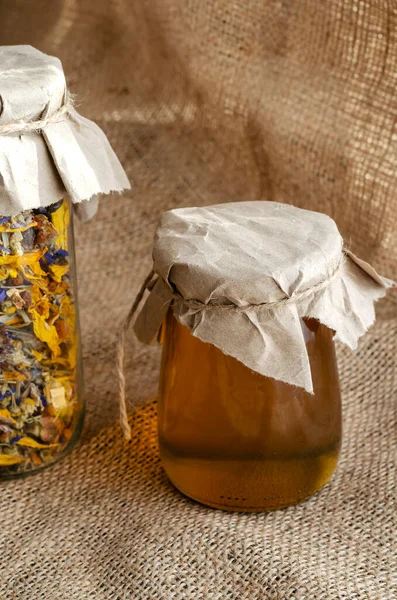ハーブや代替医療の概念 ハーブの薬用乾燥ハーブや蜂の蜂蜜 乾燥花茶と生の液体蜂蜜ガラス瓶の中にバラップ — ストック写真