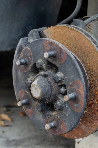 Close-up of the wheel hub without the wheel. Front wheel hub with studs and rusted brake disc. Auto shop. No people.