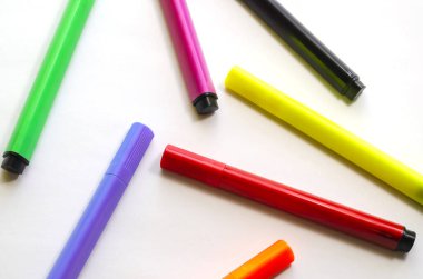 Beyaz arka planda rastgele keçeli kalemler. Parlak renkli keçeli kalemler. Yaratıcılık, çizim, ev eğlencesi konsepti. Seçici Odaklanma.