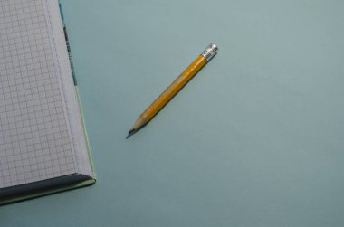 Mühendislik, muhasebe, iş, eğitim kavramı. Eski sarı tahta kalem ve mavi arka planda açık kare defter. Seçici odak.