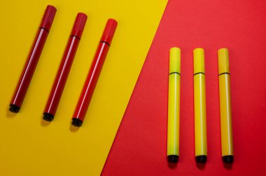 Kırmızı ve sarı keçeli kalemli yaratıcı iki renkli kompozisyon. Kırmızı ve sarı arka planda altı renkli keçeli kalem..