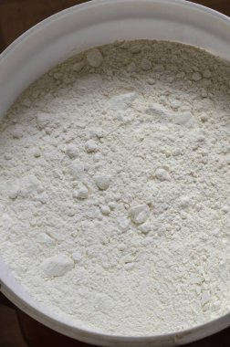 Büyük plastik kova buğday unu. Çeşitli yemekleri hazırlamak için bir malzeme. Yukarıdan bir açıdan bak. Seçici odak.