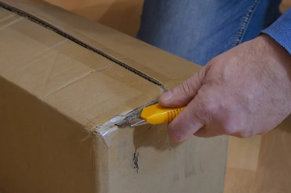 Hombre Con Cuchillo Amarillo Abre Parcela Caja Cartón Rectangular Cerrada — Foto de Stock