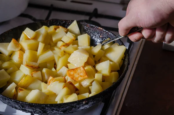 Férfi Kéz Egy Kanállal Keveri Szeletelt Burgonya Egy Serpenyőben Konyhában — Stock Fotó