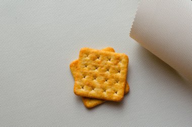 Beyaz desenli arka planda kare tuzlu krakerler. Yiyecek, atıştırmalık, gastronomi..