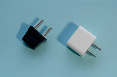Siyah ve beyaz değiştirilebilir DC ve AC prizleri. Mavi arka planda ABD ve Avrupa için duvar adaptörleri.