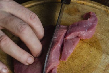 Et yemeği pişiriyorum. Bir adam biftek stroganoff için bir et dilimleme.