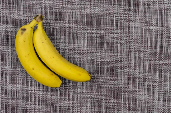 两个成熟的香蕉 红白相间的褐色斑点 有机食品 复制空间 平躺在床上 — 图库照片