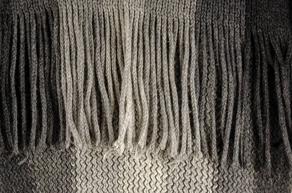 グレーで細かくチェックされたウールの質感のクローズアップ 冬のテクスチャコンセプト フリンジスカーフ ニットの服 機械は毛織物を編んだ 選択的焦点 ノイズの多いテクスチャ — ストック写真