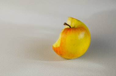 Beyaz arka planda yarısı yenmiş bir elma. Beyaz arka planda ısırılmış olgun bir elma. Seçici odak.