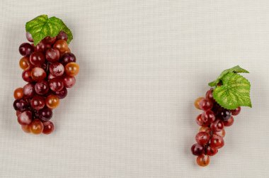 Açık kahverengi arka planda iki kırmızı üzüm kümesi. Yemek, malzemeler. Düz Yat.