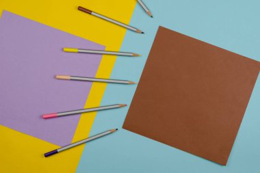 Çok renkli arkaplanda renkli kalemlerle Geometrik bileşim. Kahverengi kareye dikkat edin. Uzayı kopyala Üst Manzara Düz Yat