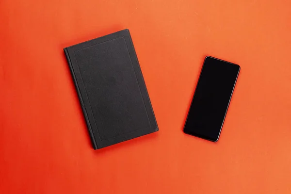 Zwarte Smartphone Gesloten Papieren Boek Een Rode Achtergrond Voordelen Van — Stockfoto