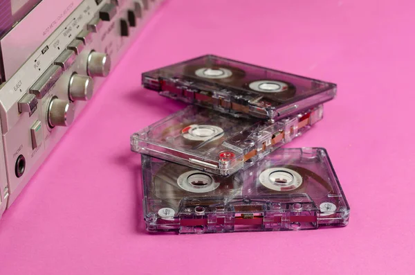 Boombox Stereo Radio Cassette Recorder and random cassettes on pink background. Vintage Cassette Deck,  retro technology. View from above at an angle, selective focus.