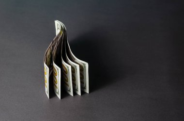 Fotokopi alanı olan 100 dolarlık banknotlar içeren yaratıcı bir özgeçmiş. Gri arka planda dikey olarak yerleştirilmiş beş banknot. Yakın çekim, seçici odaklanma.