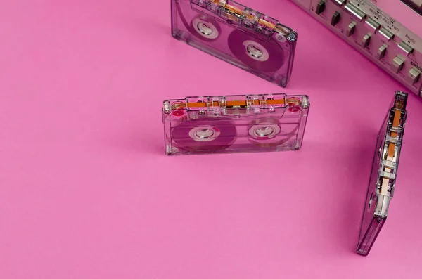 Müzik Kutusu Stereo Radyo Kasetçalar ve pembe arka planda rastgele kasetler. Antika Kaset Güvertesi, geçmişe dönük teknoloji, seçici odaklanma.