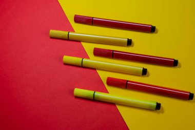 Kırmızı ve sarı keçeli kalemli yaratıcı iki renkli kompozisyon. Kırmızı ve sarı arka planda altı renkli keçeli kalem..