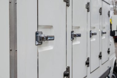 Özel ticari ulaşım konsepti. Küçük soğutmalı kamyon. Donduruculu minibüsün kapıları ve kilitleri ayrı bölümlerde. Seçici odak.